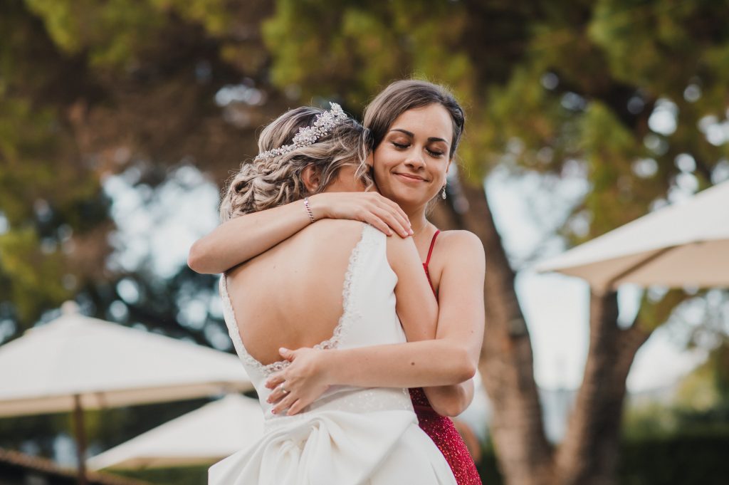 A woman hugs her bride and friend